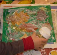 enfant en train de mettre des paillette sur des feuilles d'arbre