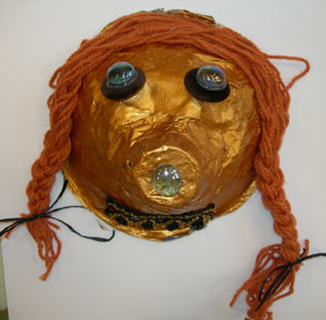 masque en papier maché peint et décoré de bouton