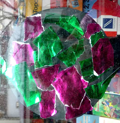 boule de noel faite avec un disque noir recouvert de papiers déchirés brillants