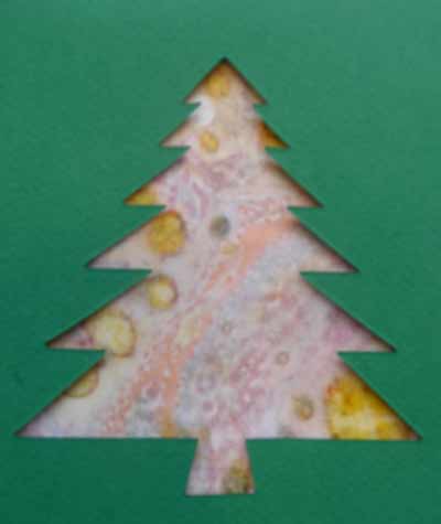 carte avec une découpe de sapin et un fond en marbling