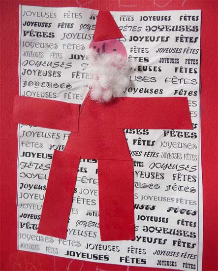 carte avec un fond écrit et un père-noël en papier rouge collé