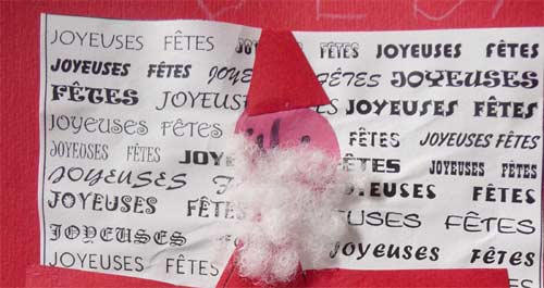 gros plan de la carte avec un fond écrit et un père-noël en papier rouge collé