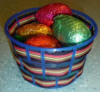 panier avec un support plastique de récupération et du ruban contenant des oeufs de Pâques