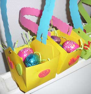 paniers de Pâques en papier décoré contenant des oeufs en chocolat